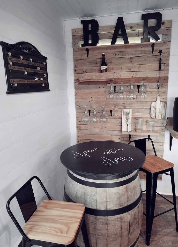 a bar with two stools next to a wine barrel