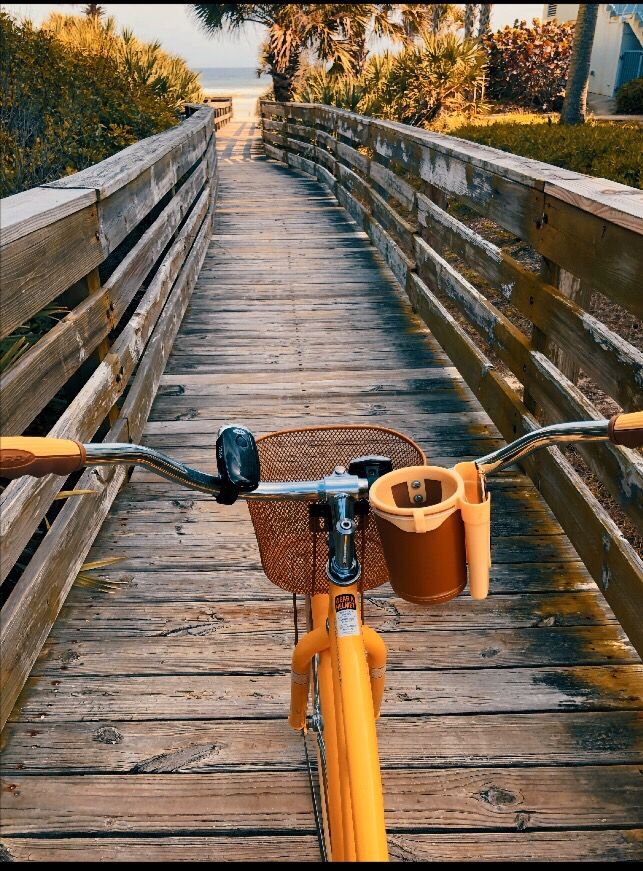 a yellow bicycle parked on a wooden bridge