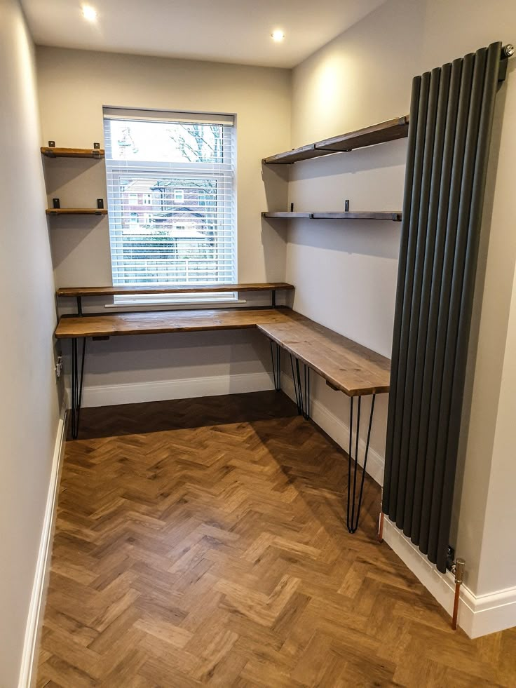 an empty room with some shelves on the wall and a radiator in the corner