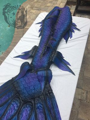 a large blue fish laying on top of a white sheet next to a swimming pool