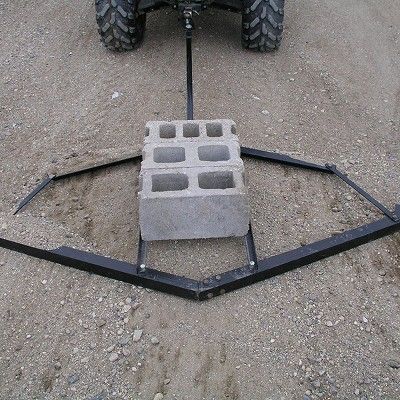 a cement block sitting in the middle of a dirt field next to a tractor tire