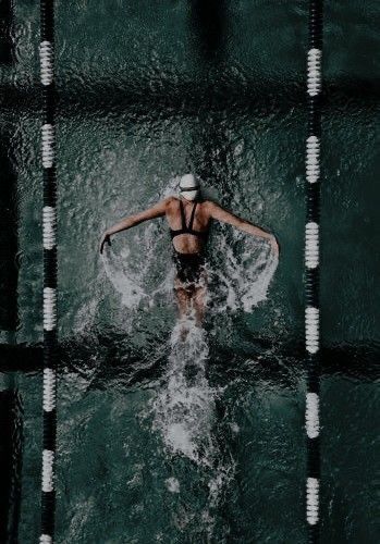 a woman swimming in the water with no shirt on