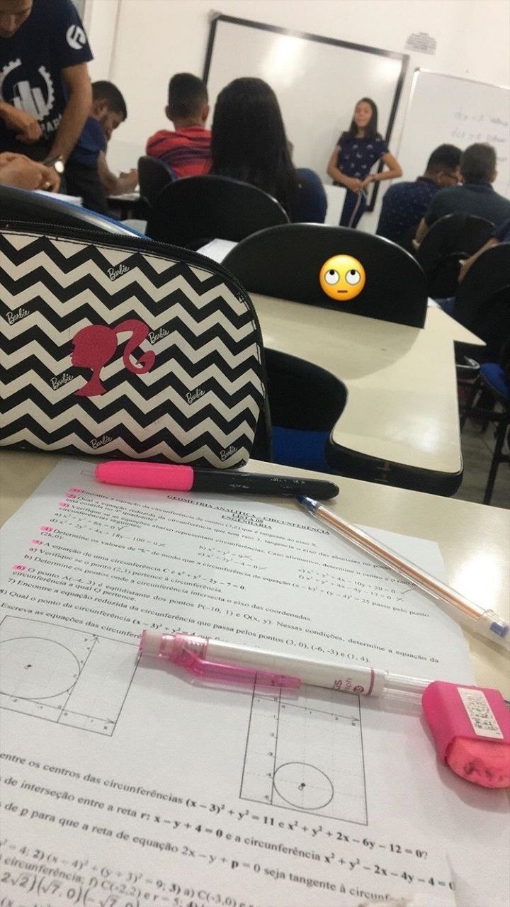 a black and white purse sitting on top of a table next to a pencil holder