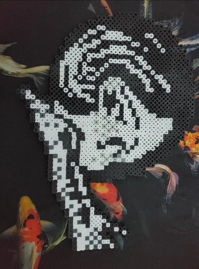 an image of a woman with fish in her hair made out of perler beads