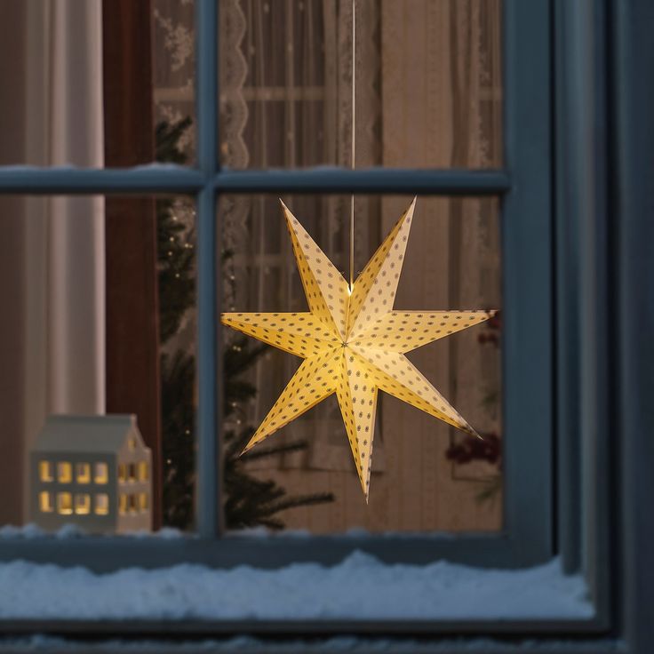 a yellow star hanging from the side of a window