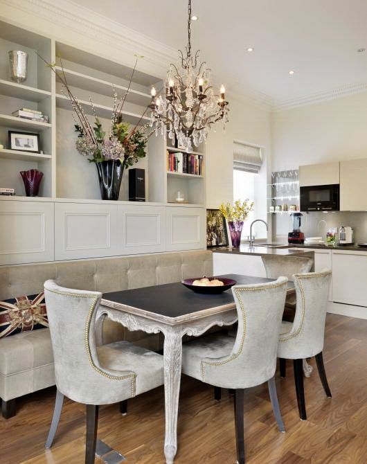 a dining room table with four chairs and a chandelier hanging from the ceiling