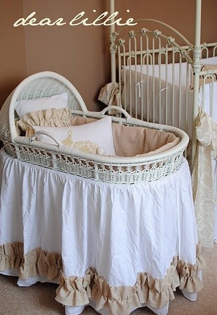 a white crib with ruffled bedspread and pillows