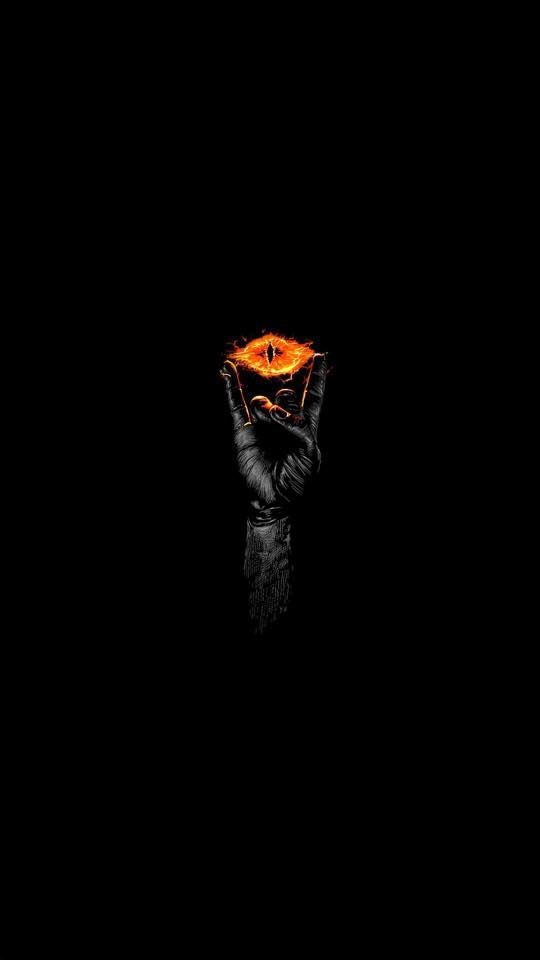 a person holding up an orange object in the dark