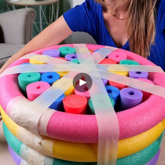 a woman sitting at a table with a large cake made out of doughnuts