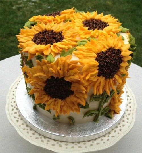 a cake decorated with sunflowers on top of a table