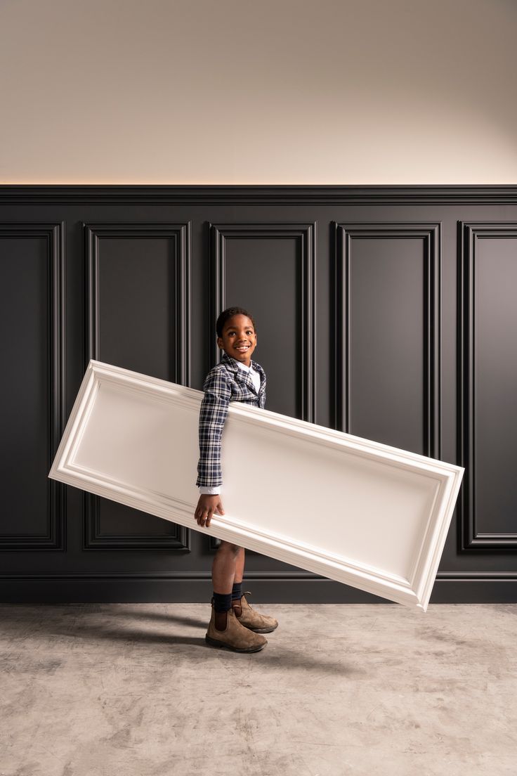 a young boy is holding a large white tray