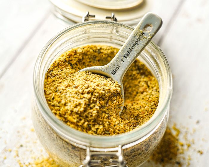 a jar filled with yellow powder and a spoon