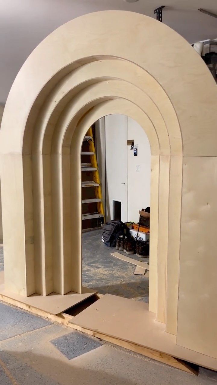 an arch in the middle of a building being built with plywood and wood shavings