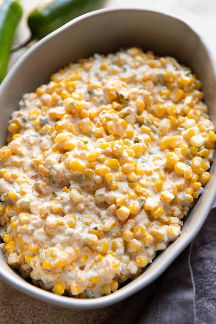 a white bowl filled with corn on top of a table