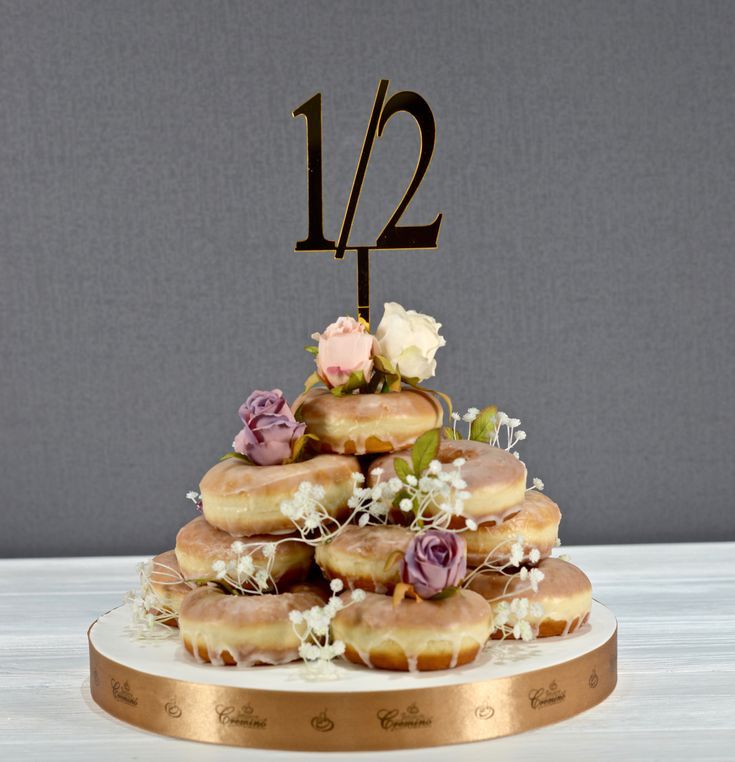 there is a cake with donuts on it and flowers in the top tiers