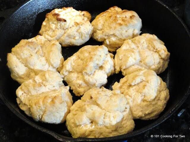 some biscuits are cooking in a skillet on the stove top and it looks like they have been cooked