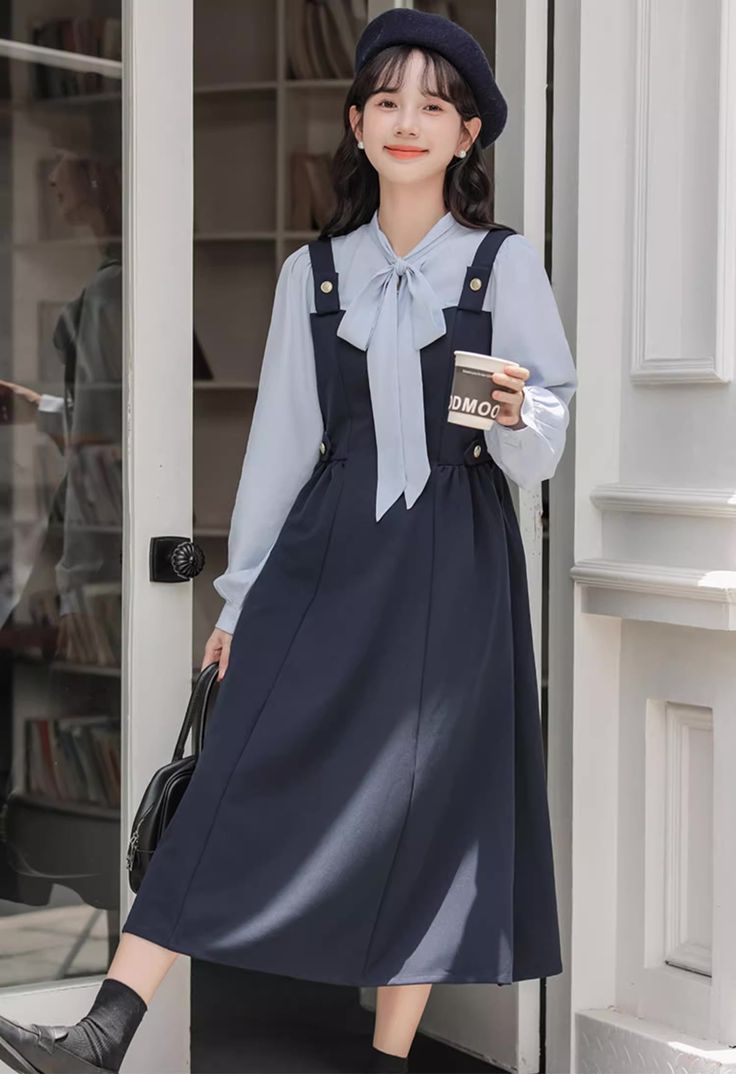 Preppy twofer midi dress with a faux layered look. Features tie neck blouse with long sleeves, a cami pinafore bodice with side pockets and embellished with golden buttons. Concealed side zipper closure. S: 33" chest, 26" waist, 44" lengthM: 34.5" chest, 27.5" waist, 44" lengthL: 36" chest, 29" waist, 44.5" lengthXL: 37.5" chest, 30.5" waist, 44.5" length Midi Dress Navy, Blouse With Long Sleeves, Fall Photo, Fall Photoshoot, Tie Neck Blouse, Navy Midi Dress, Pinafore Dress, Midi Skirts, Overall Dress