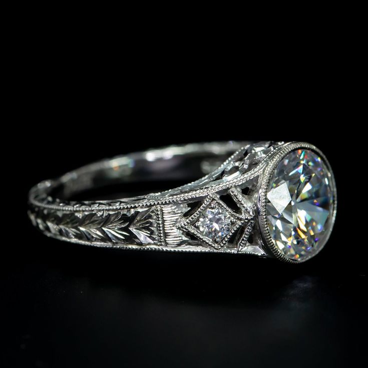 an antique style diamond engagement ring with filigrees