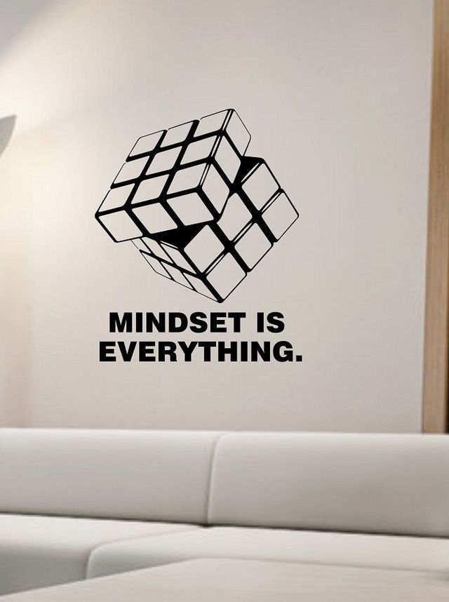 a living room with a white couch and black wall decal that says mindset is everything