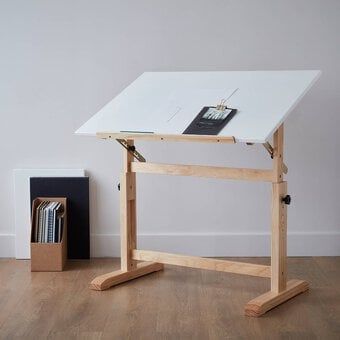 a desk with a white top and wooden legs in front of a bookcase on a hard wood floor