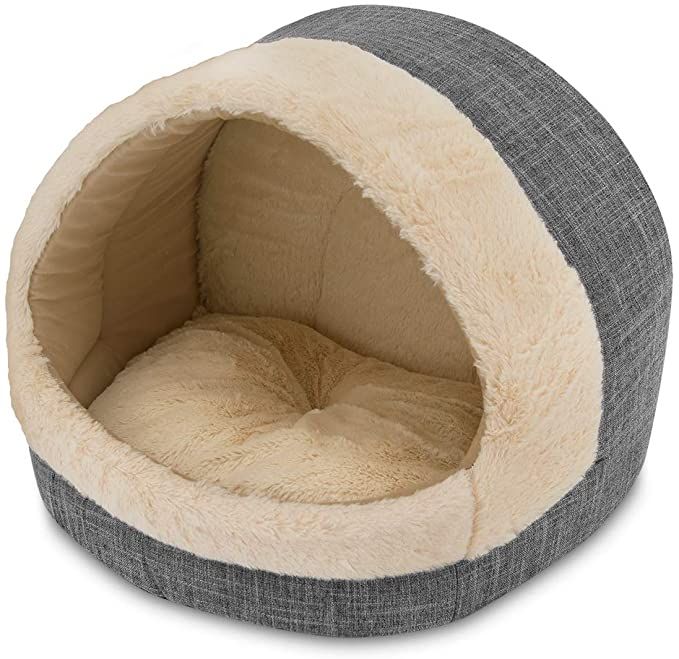 a dog bed that is made out of fabric and has a grey, white and beige color