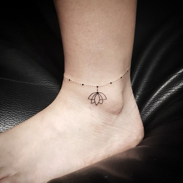 a woman's foot with a small flower tattoo on the side of her ankle