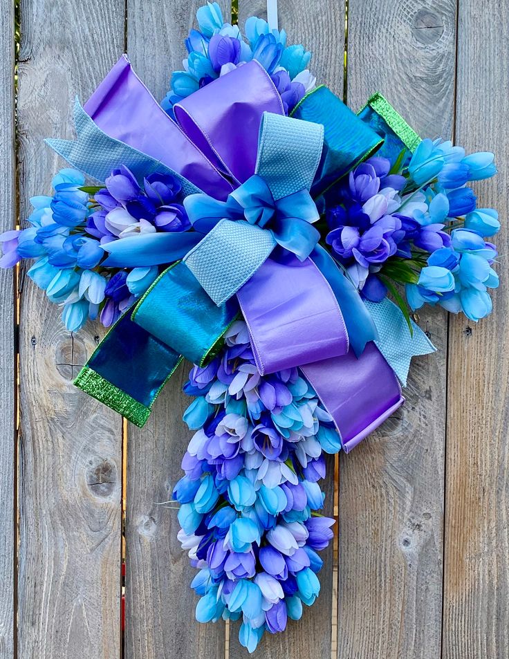 a purple and blue wreath on top of a wooden fence