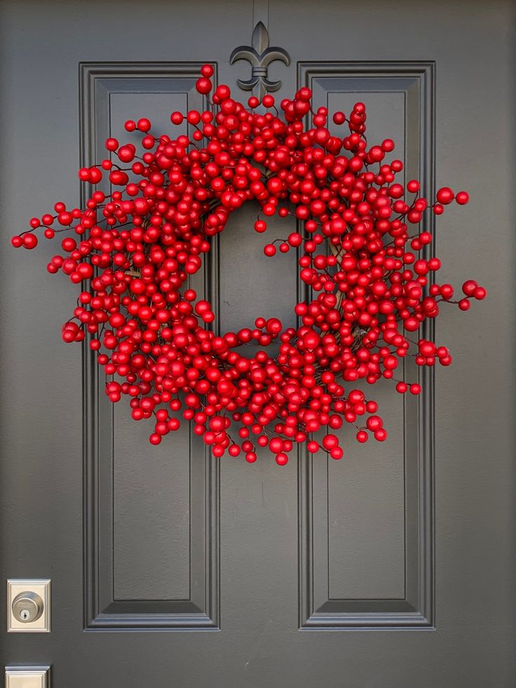 a red berry wreath on the front door