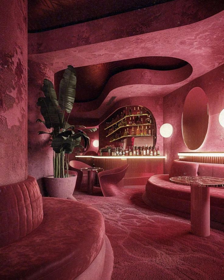 a pink room with round tables and couches