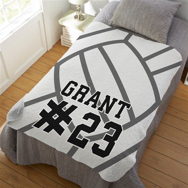 a bed covered in a blanket with the number 22 on it and a volleyball ball