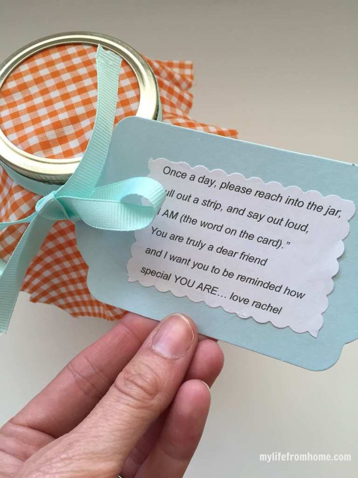 a person holding up a card with a ring on it and a message attached to it