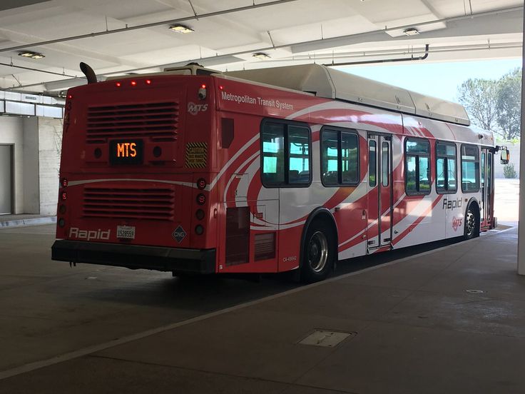 a red and white bus parked in a garage