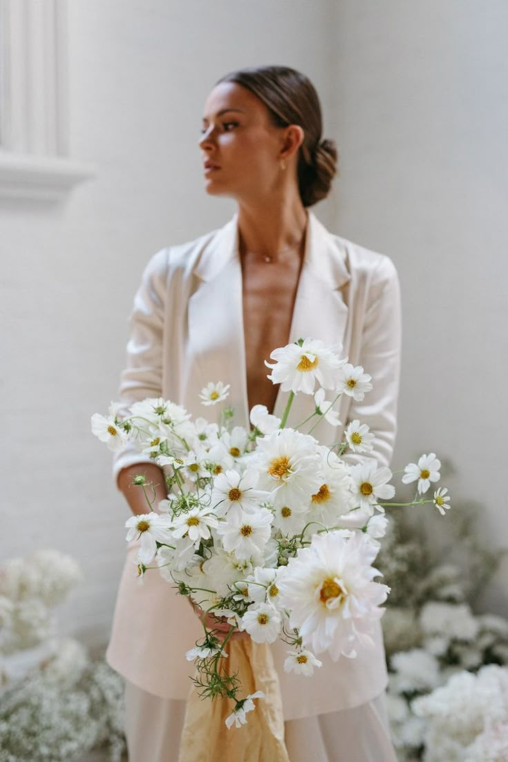 a woman holding a bouquet of white flowers