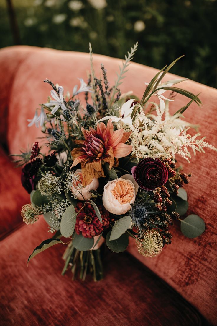 a bouquet of flowers sitting on top of an orange couch