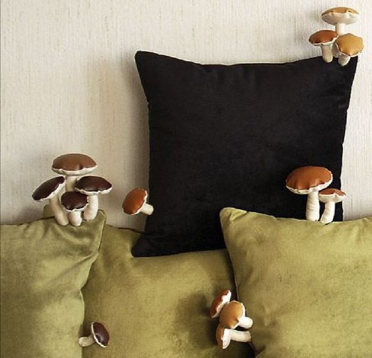 three pillows with mushrooms on them sitting next to each other