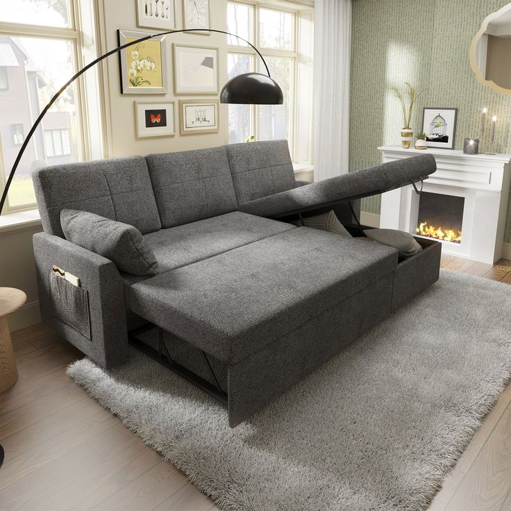 a living room scene with focus on the sofa and pull out bed in the middle