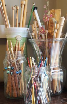 several glass jars filled with different types of pens and pencils