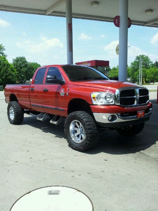 a red truck parked in front of a gas station