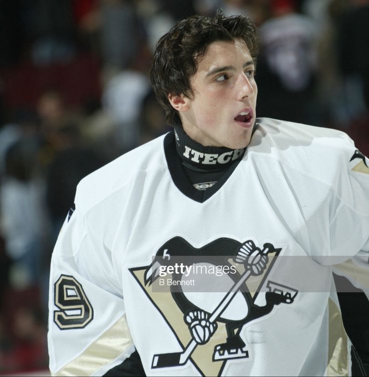 a hockey player with his mouth open in front of the crowd at an ice rink