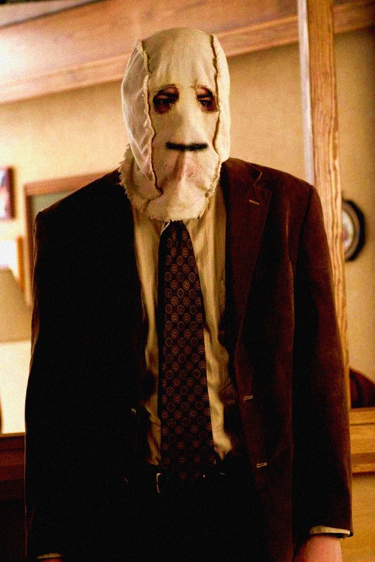 a man in a suit and tie wearing a mask