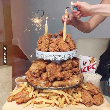 a person lighting candles on top of some fried food with fries and ketchup