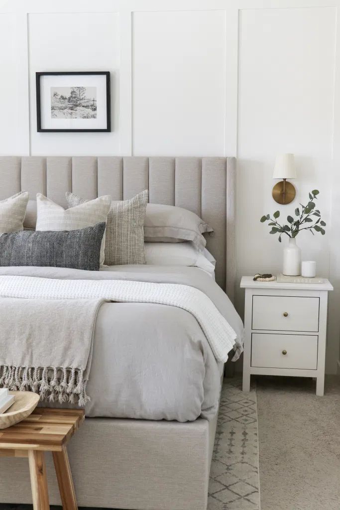 a bedroom with a bed, nightstands and pictures hanging on the wall above it