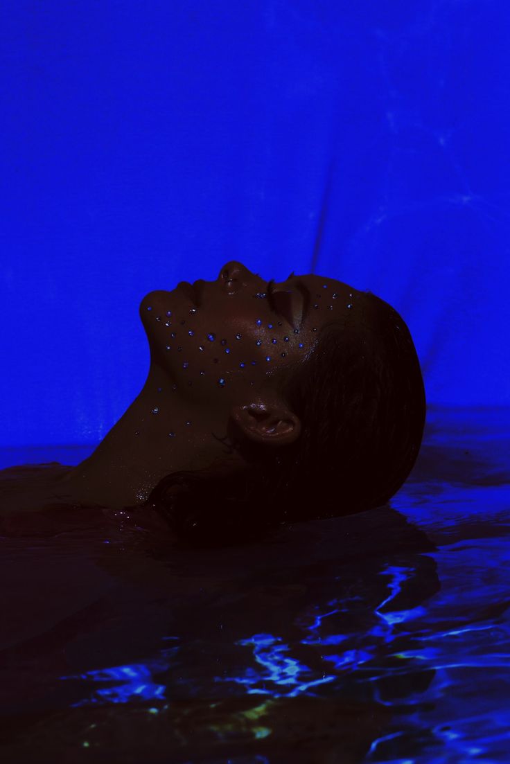 a woman floating in the water with her eyes closed