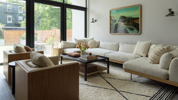 a living room filled with furniture and large windows