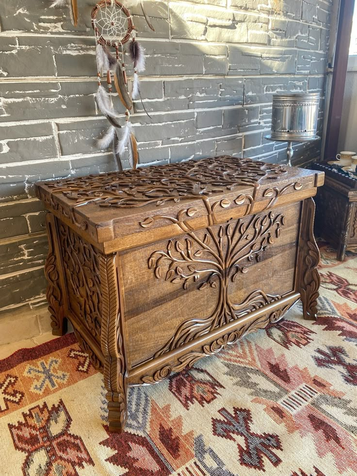 an ornate wooden chest in front of a brick wall with native american decor on it