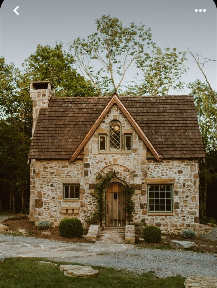 an old stone house with a brown roof