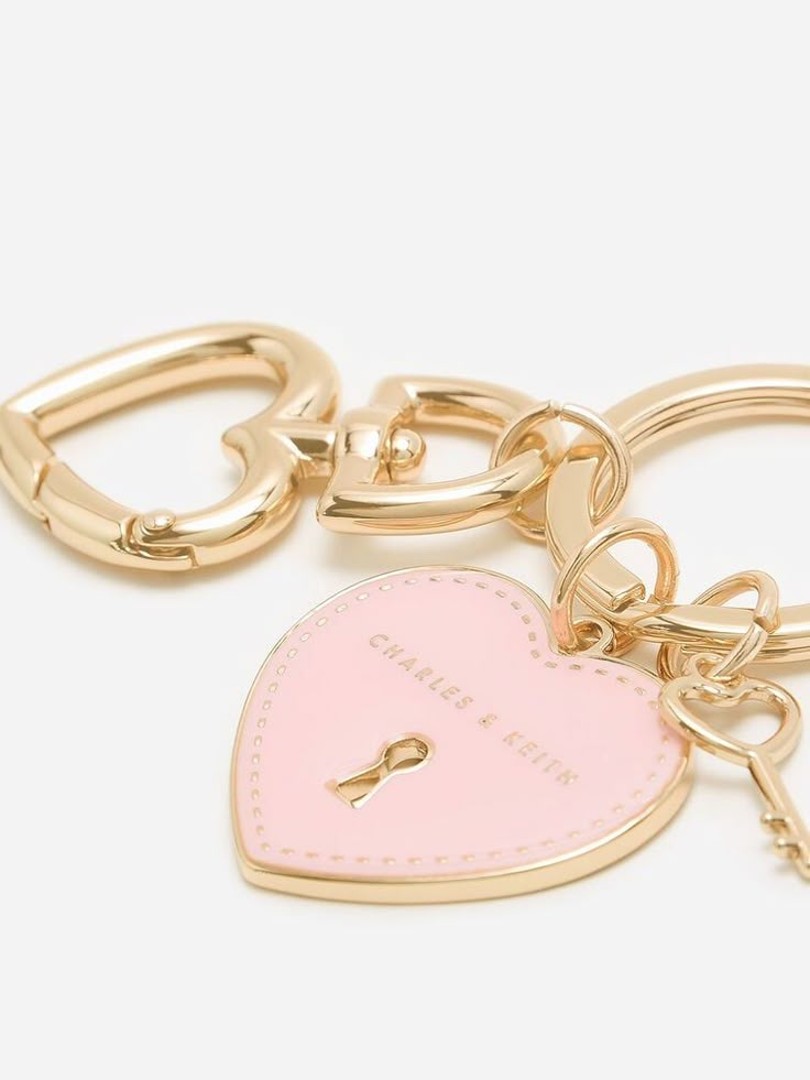 a heart shaped keychain with a lock on the front and a small pink heart in the middle