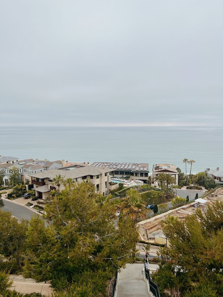 an aerial view of some houses and the ocean in the backgroung area