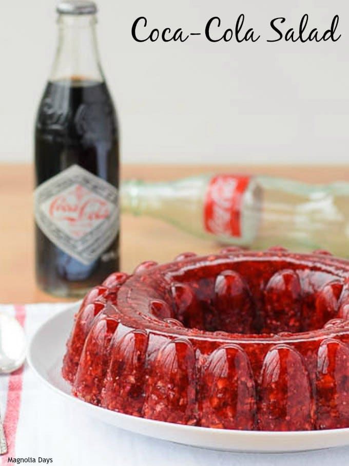 a jelly bundt cake sitting on top of a white plate next to a bottle of booze