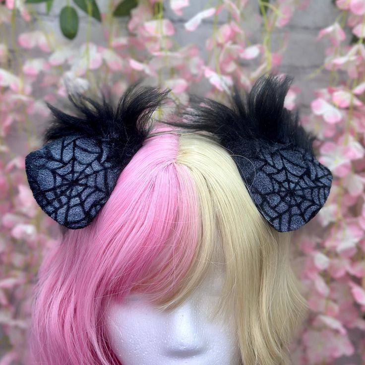 two wigs with black and pink hair on top of a mannequin head